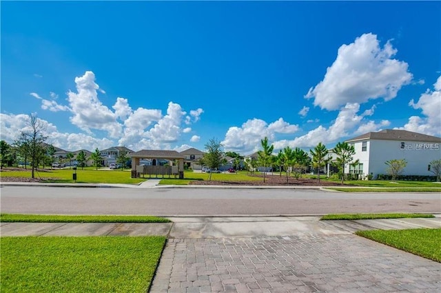 view of road with sidewalks, a residential view, and driveway