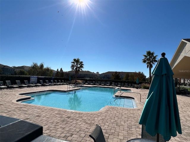 pool with a hot tub, a patio, and fence