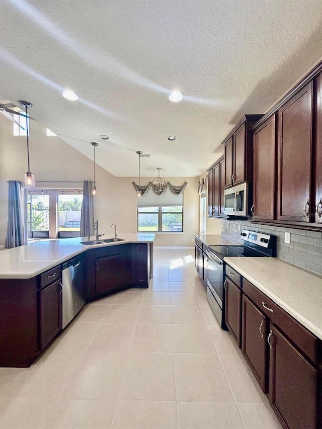 kitchen with a sink, appliances with stainless steel finishes, light tile patterned floors, and dark brown cabinets