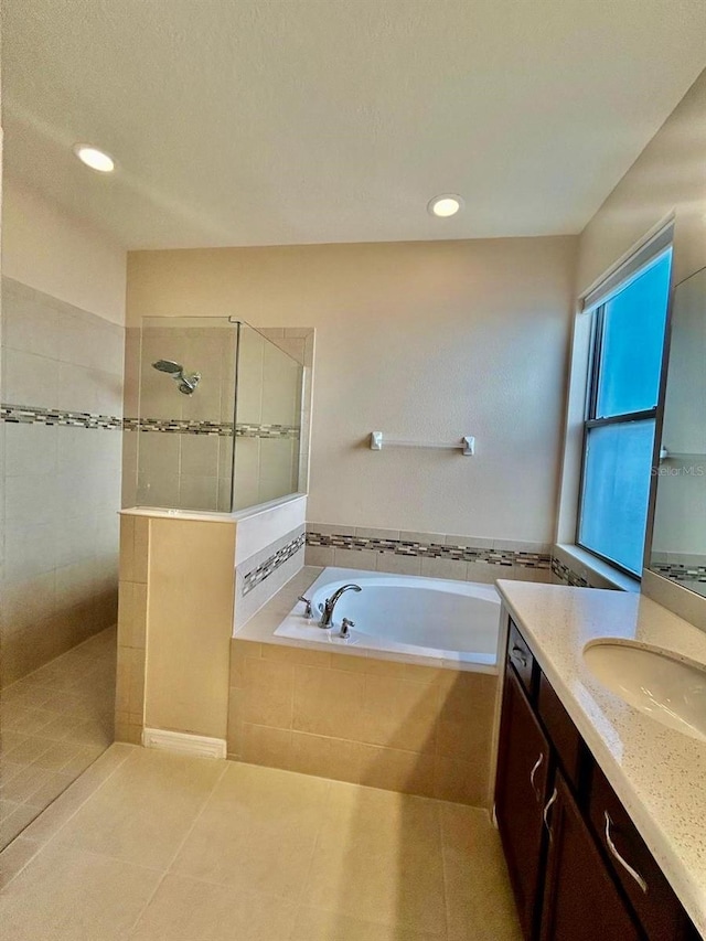 bathroom with tile patterned floors, a walk in shower, recessed lighting, a bath, and vanity