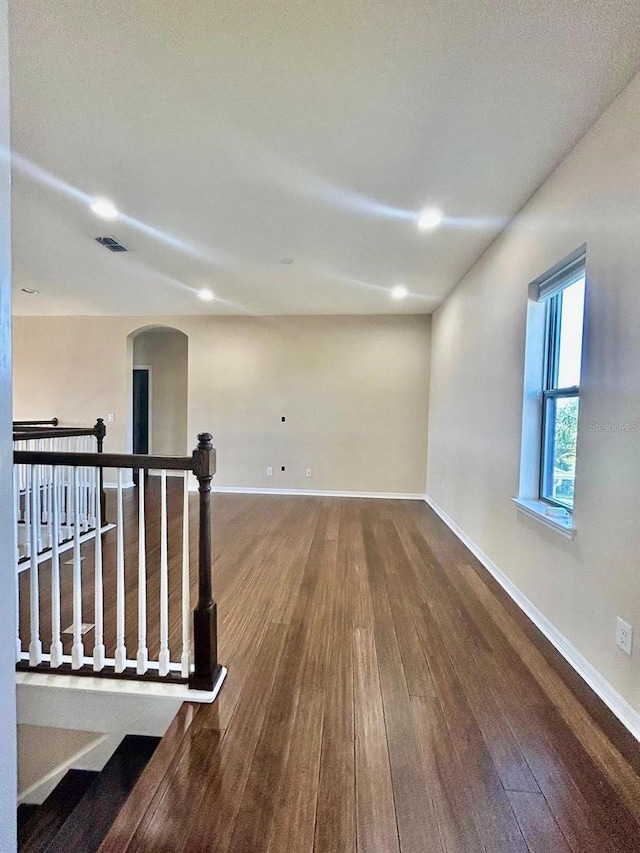 empty room with visible vents, baseboards, and wood finished floors