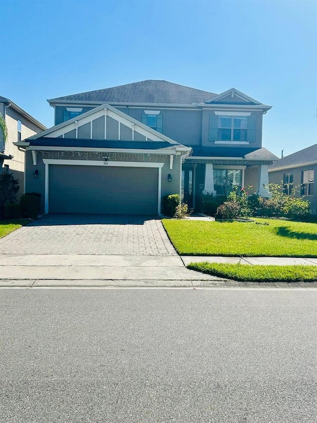 view of front of house with a garage, stucco siding, driveway, and a front lawn