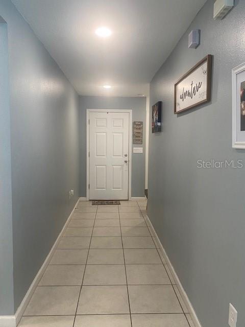 hall with light tile patterned floors