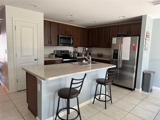 kitchen with visible vents, light countertops, light tile patterned floors, appliances with stainless steel finishes, and a sink