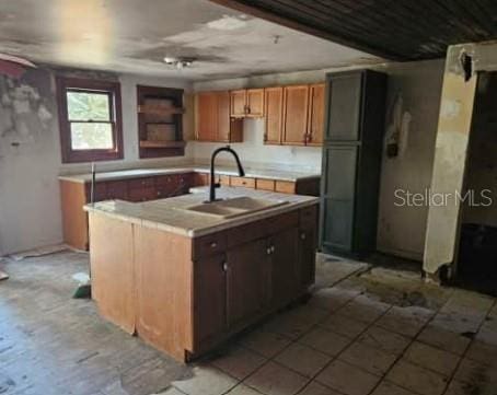 kitchen featuring sink and a kitchen island with sink