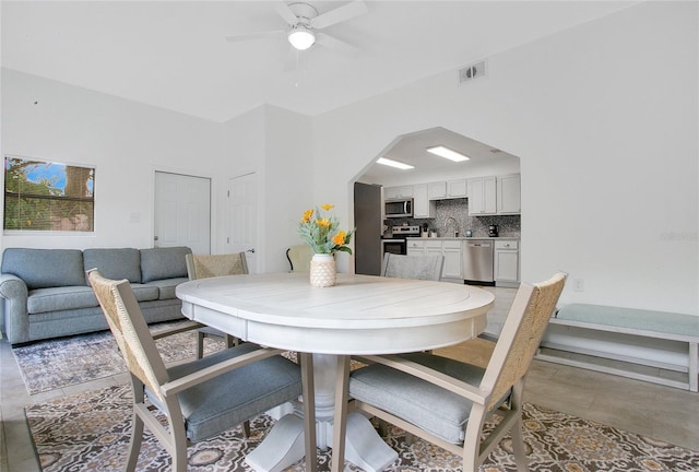 dining room featuring ceiling fan and sink