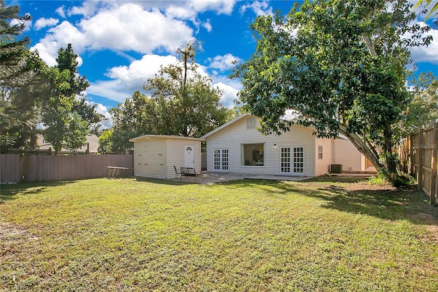 rear view of property with central AC, french doors, a lawn, and a patio