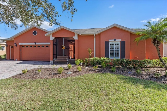 single story home featuring a garage and a front lawn