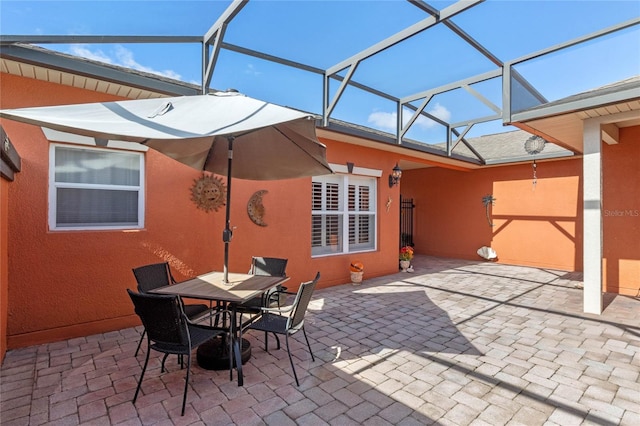 view of patio featuring glass enclosure