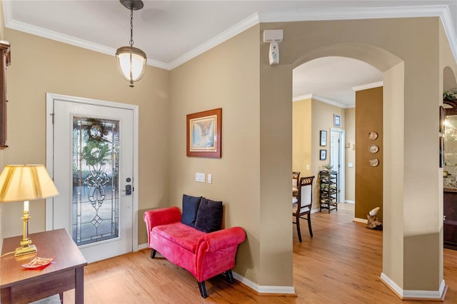 foyer entrance featuring crown molding and light wood-type flooring