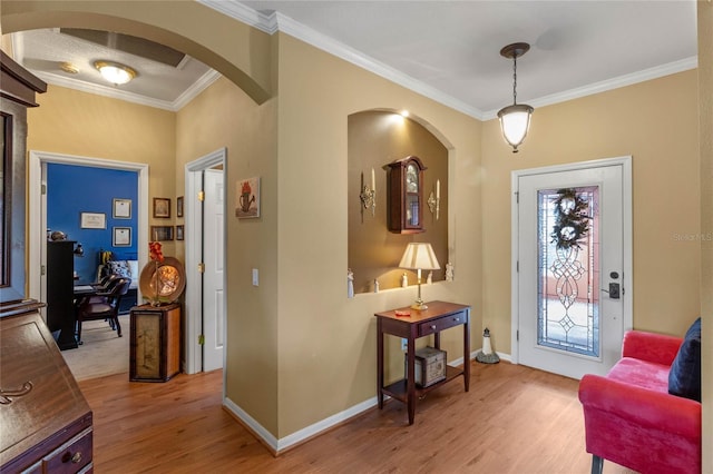 entryway with light wood-type flooring and crown molding