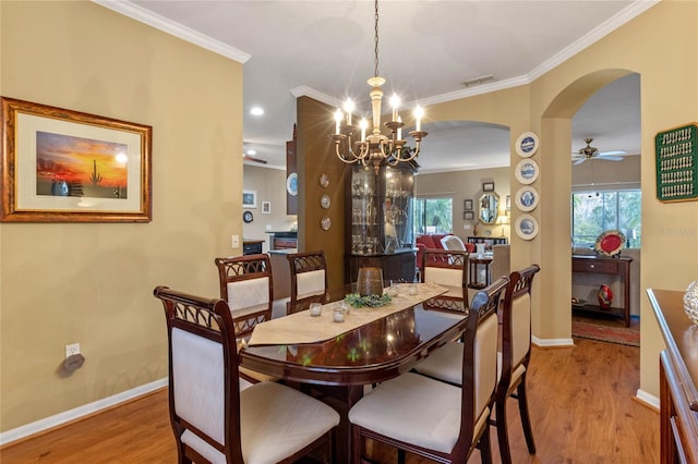 dining area featuring ceiling fan with notable chandelier, crown molding, and light hardwood / wood-style flooring