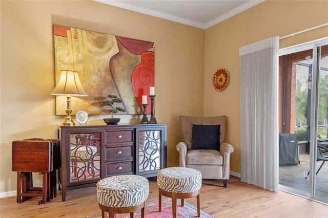 living area with light hardwood / wood-style floors and ornamental molding