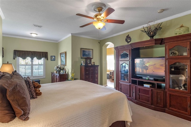 bedroom with ceiling fan, carpet floors, a textured ceiling, and ornamental molding