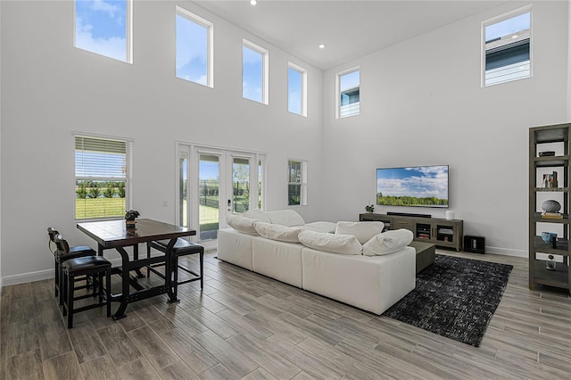 living room featuring a towering ceiling and french doors