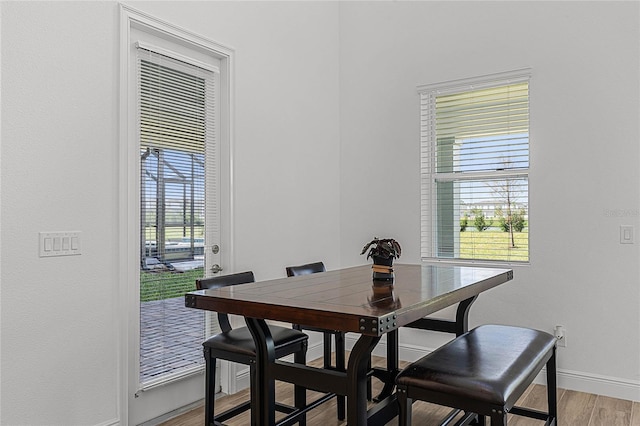 dining area featuring light wood-style floors and baseboards