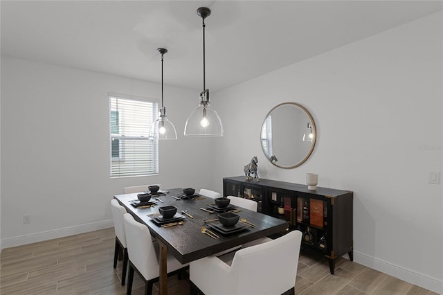 dining space with baseboards and wood tiled floor