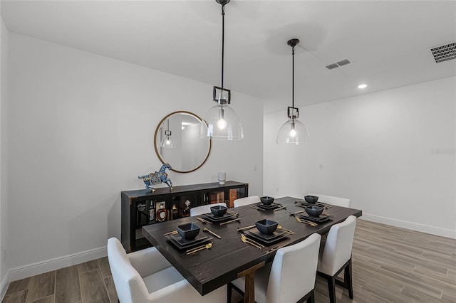 dining room with baseboards, visible vents, wood finished floors, and recessed lighting