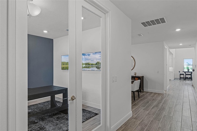 interior space featuring wood tiled floor, visible vents, baseboards, and recessed lighting