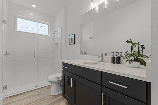 full bathroom with toilet, recessed lighting, a stall shower, wood finished floors, and vanity