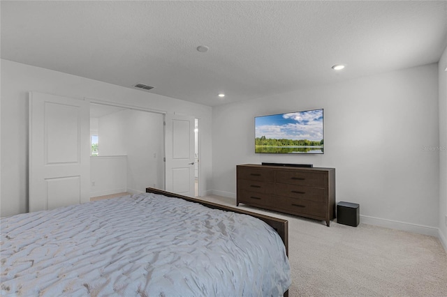 carpeted bedroom with a textured ceiling, recessed lighting, visible vents, and baseboards