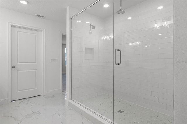 full bathroom featuring a textured ceiling, visible vents, baseboards, marble finish floor, and a stall shower