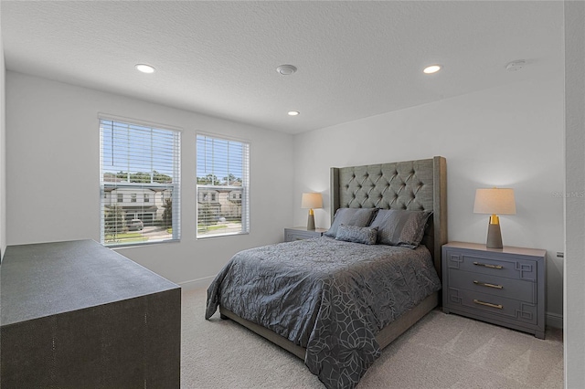 bedroom featuring recessed lighting, light colored carpet, and a textured ceiling