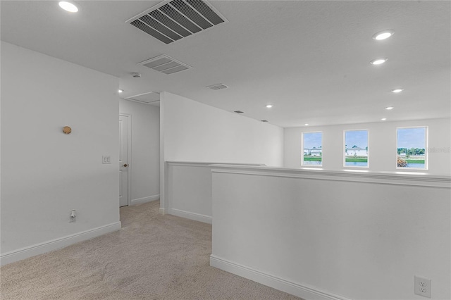 empty room with recessed lighting, baseboards, visible vents, and light carpet