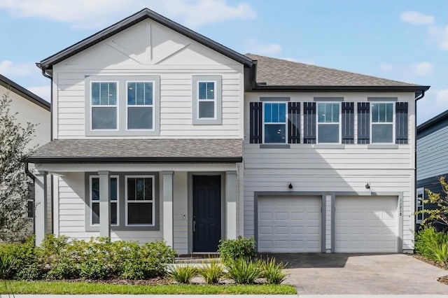 view of front facade with an attached garage, driveway, and a shingled roof