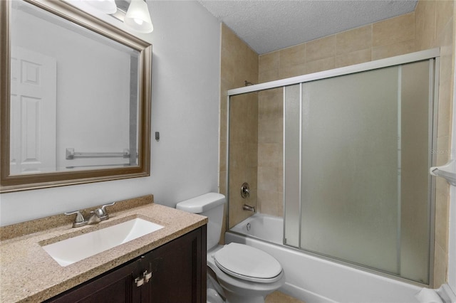 full bathroom featuring vanity, toilet, bath / shower combo with glass door, and a textured ceiling