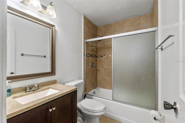 full bathroom featuring toilet, combined bath / shower with glass door, a textured ceiling, and vanity