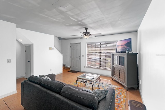 living room featuring stairs, ceiling fan, baseboards, and light tile patterned floors