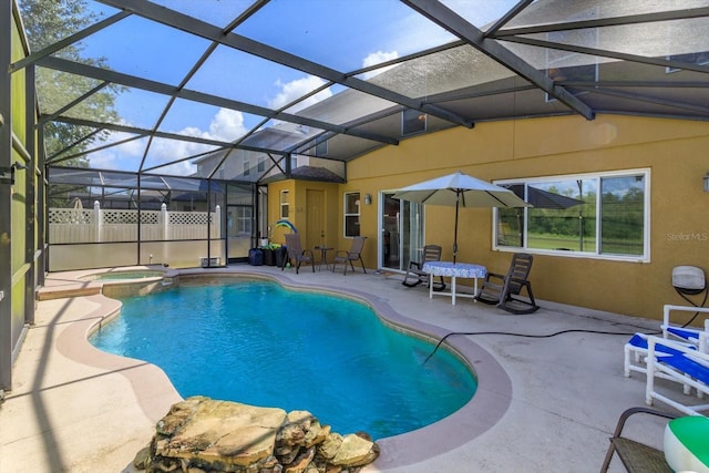 view of pool featuring an in ground hot tub, glass enclosure, and a patio