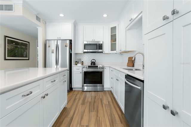 kitchen with dark wood-type flooring, white cabinetry, sink, and stainless steel appliances