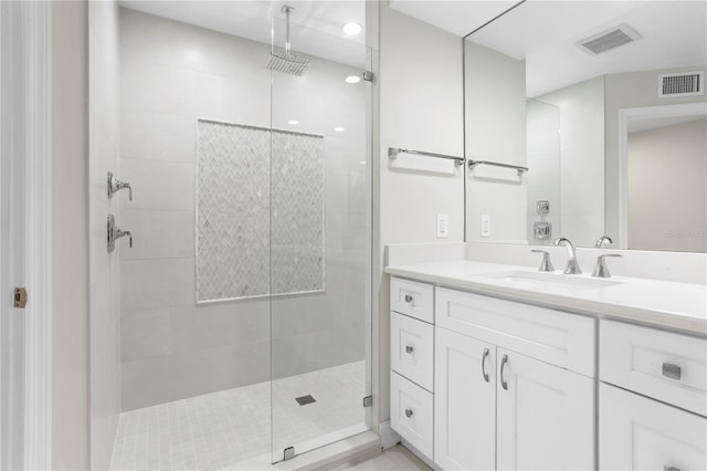 bathroom with a tile shower and vanity