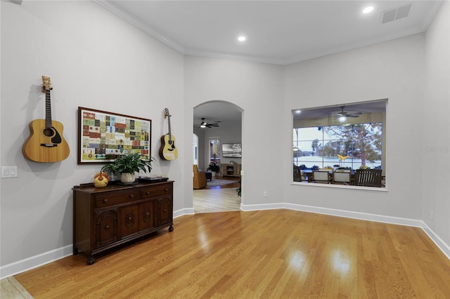 hall with crown molding and light hardwood / wood-style floors