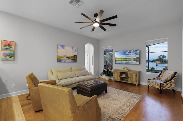 living room with ceiling fan and dark wood-type flooring