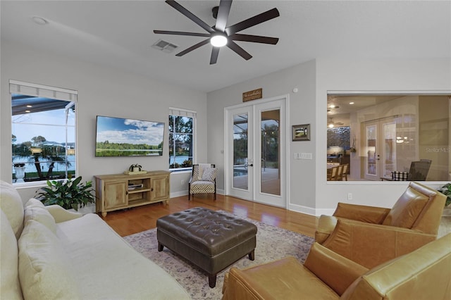 living room with a healthy amount of sunlight, french doors, and light hardwood / wood-style floors