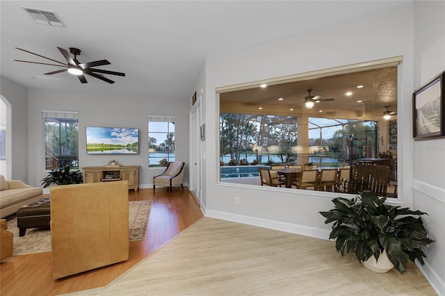 living room with hardwood / wood-style floors, plenty of natural light, and ceiling fan