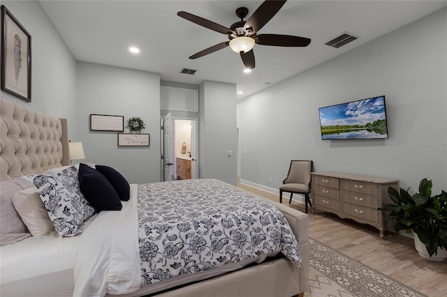 bedroom featuring ceiling fan, ensuite bathroom, and light hardwood / wood-style flooring