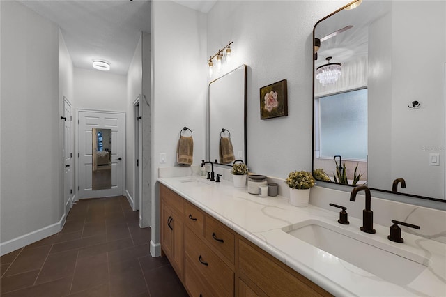 bathroom featuring a notable chandelier, vanity, and tile patterned flooring