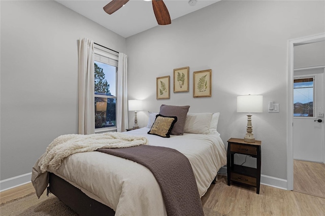 bedroom with ceiling fan, lofted ceiling, and light wood-type flooring