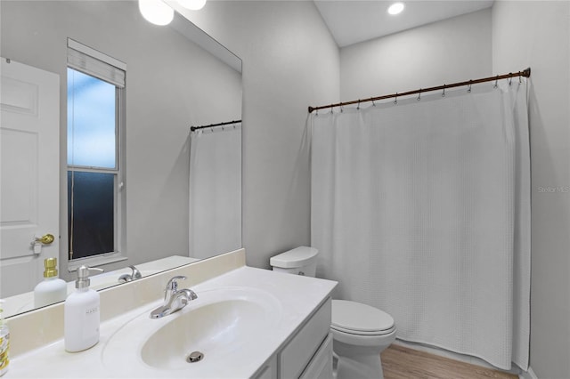 bathroom with hardwood / wood-style floors, vanity, and toilet