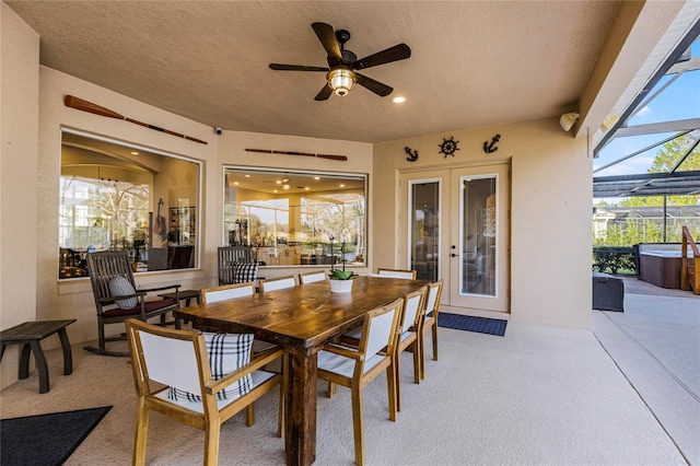 view of patio / terrace featuring ceiling fan, glass enclosure, and a hot tub