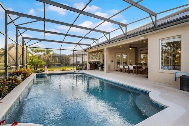 view of swimming pool featuring ceiling fan, a patio area, and glass enclosure