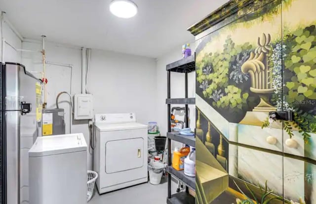 laundry area with separate washer and dryer and water heater