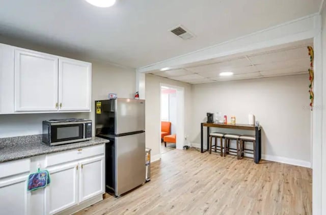 kitchen featuring white cabinets, stainless steel appliances, and light wood-type flooring