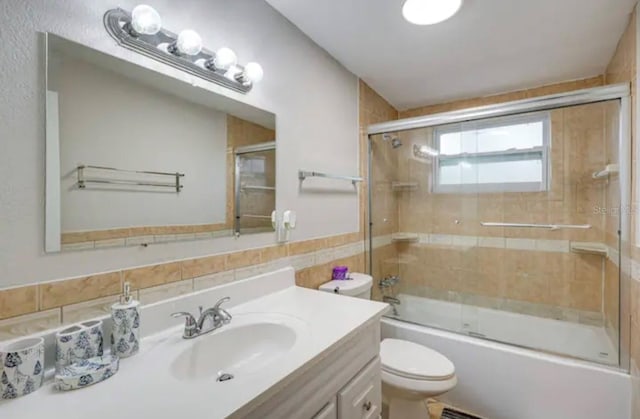 full bathroom with toilet, vanity, and combined bath / shower with glass door