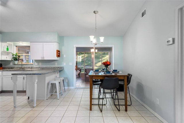 tiled dining space with a wealth of natural light and a notable chandelier