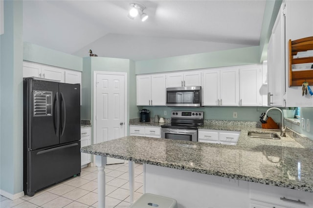 kitchen featuring white cabinetry, sink, appliances with stainless steel finishes, lofted ceiling, and stone counters